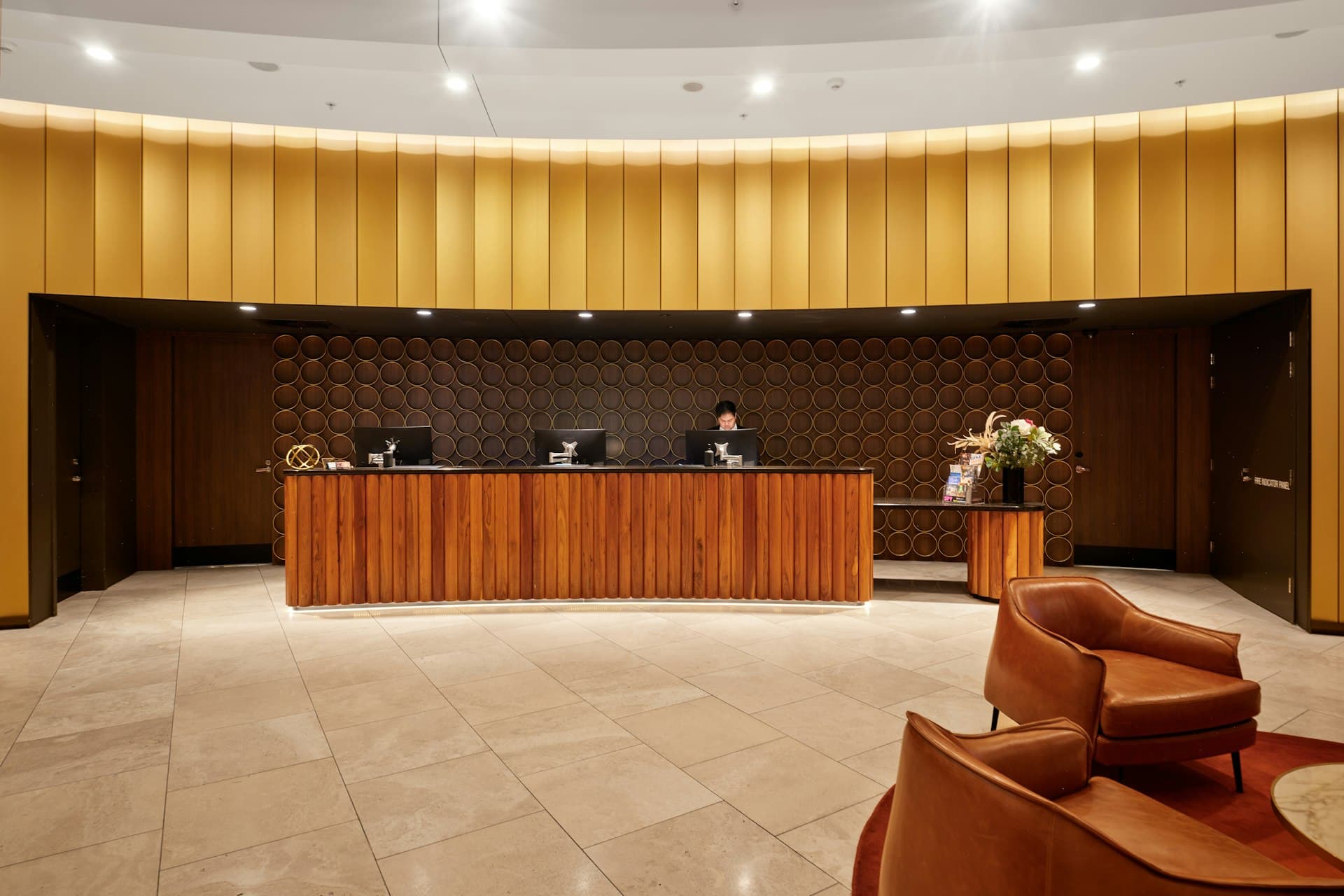 Rezeption eines Hotels mit Holztresen und Sesseln in der Lobby