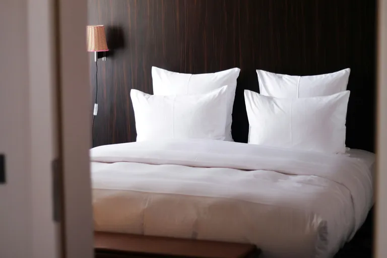 Frisch bezogenes Hotelbett mit weißen Kissen
