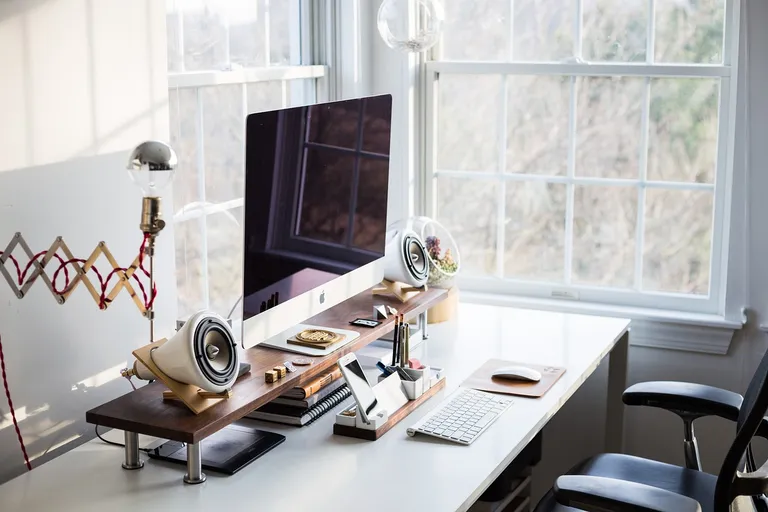 Backoffice-Arbeitsplatz eines Hotels mit Bildschirm und Belegungsplan am Fenster