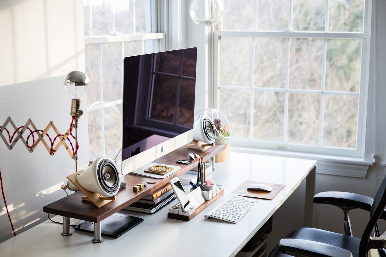 Backoffice-Arbeitsplatz eines Hotels mit Bildschirm und Belegungsplan am Fenster