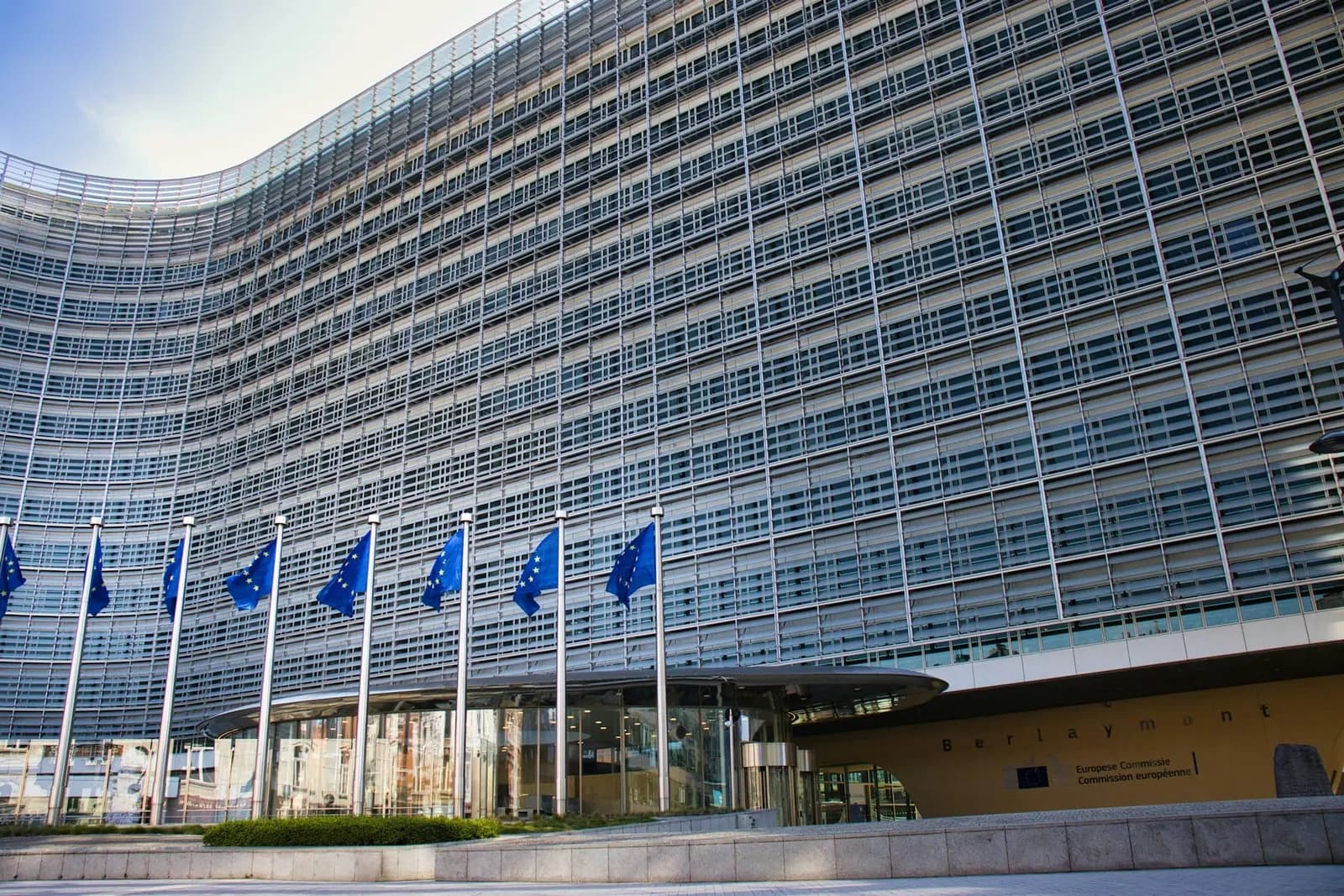 Glass building with European Union flags in front