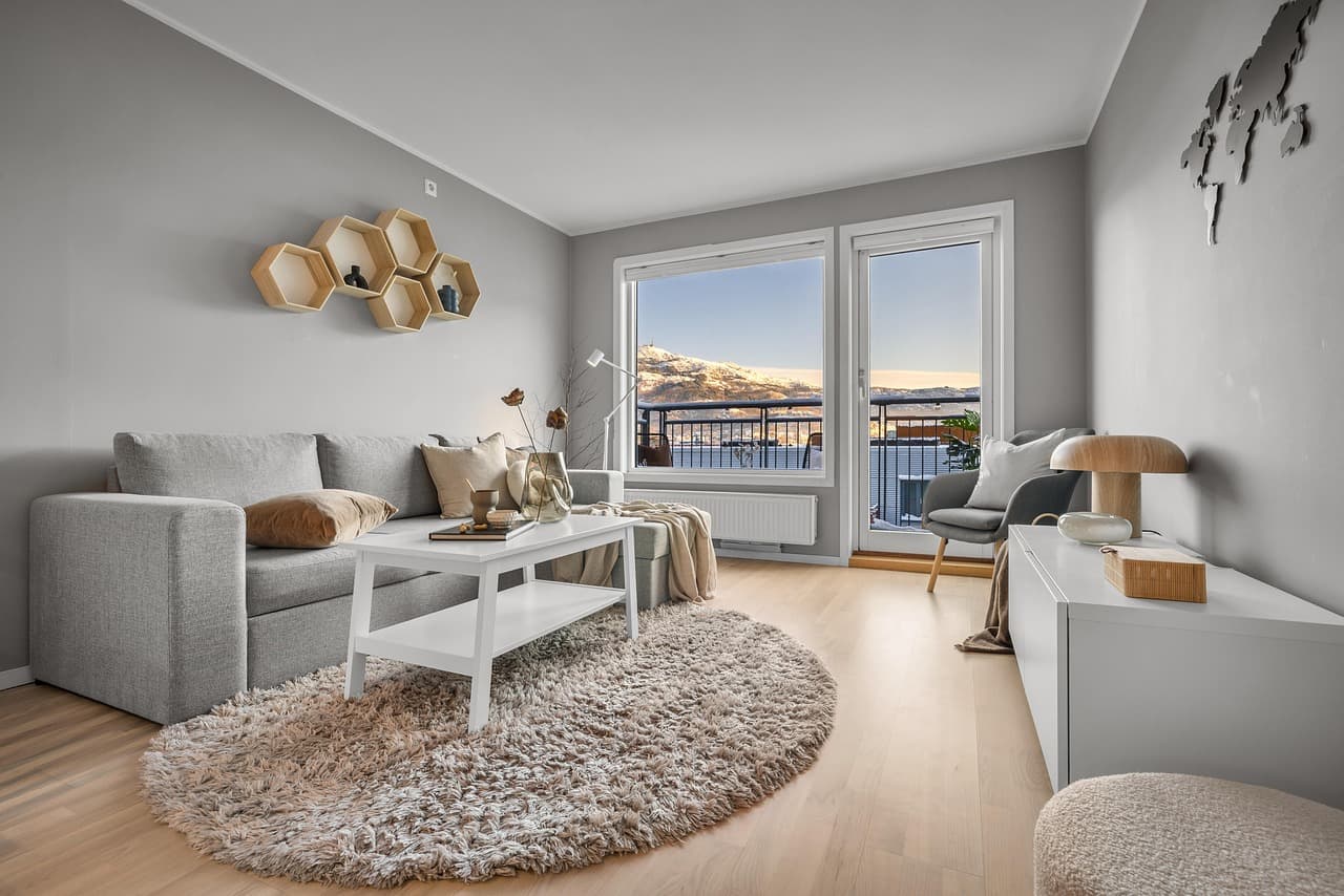 Wohnbereich einer hellen Ferienwohnung mit Holzboden und Bergblick