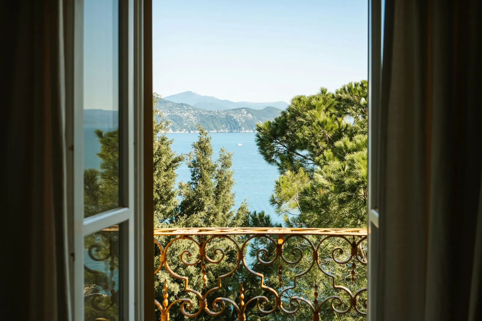 Open window with a view of trees and a lake