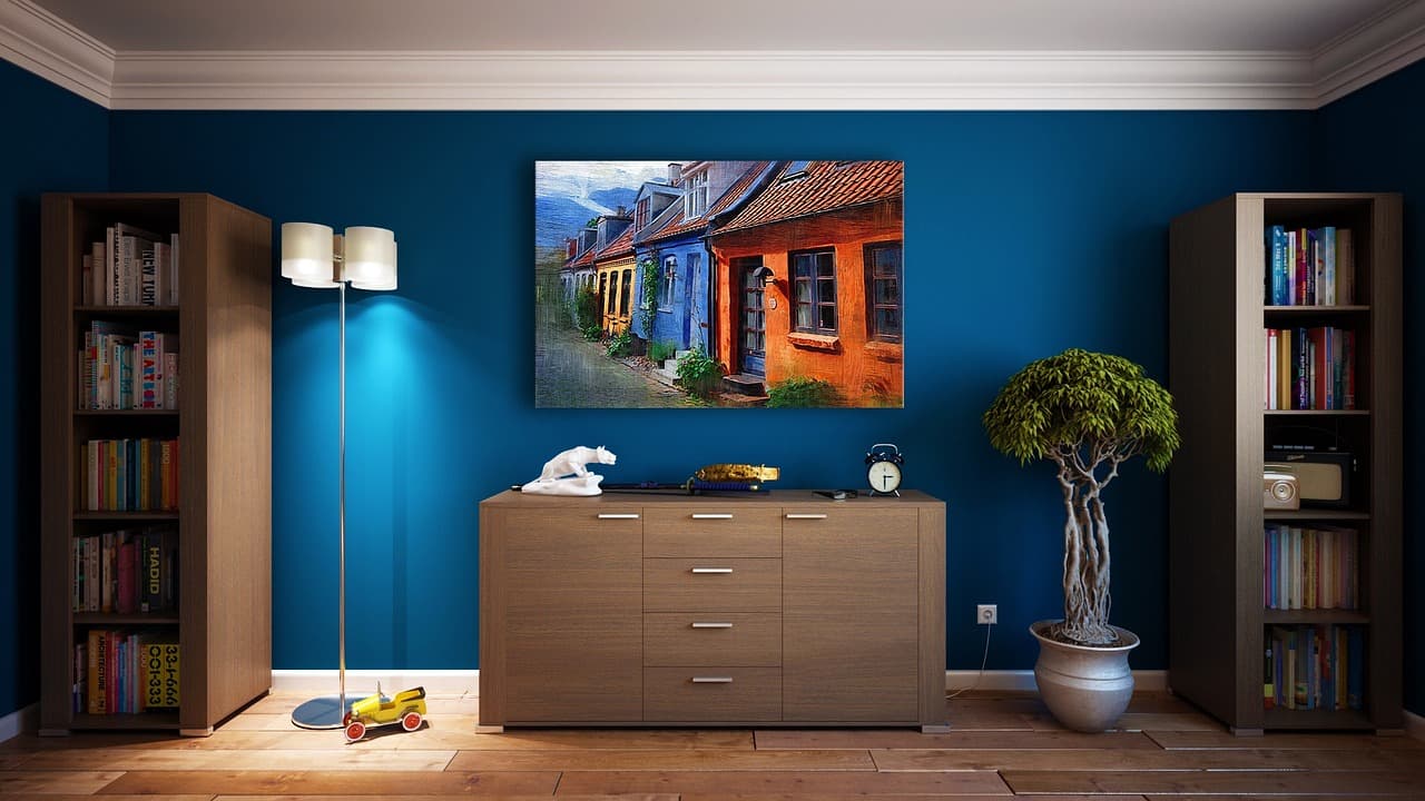 Heller Wohnraum einer Ferienwohnung mit Holzboden, Leinenvorhang und geschlossenem Laptop auf dem Tisch