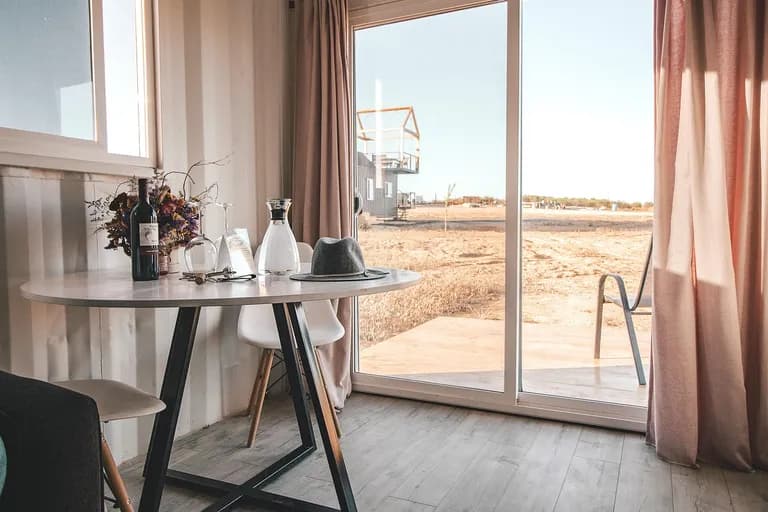 Gedeckter Frühstückstisch am Fenster eines Hotelzimmers mit Bergblick